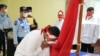 Satu dari delapan narapidana terorisme di Sumut sedang mencium bendera Merah Putih, Rabu 9 Maret 2022. (Courtesy: Humas Kemenkumham Sumut).