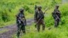 FILE - M23 rebels stand in the town of Kibumba, in the eastern of Democratic Republic of Congo, Dec. 23, 2022. Twenty-six defendants accused of belonging to the M23 rebel group are on trial in Kinshasa, with the prosecution on Monday calling for the death penalty for 25 of them.