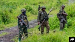 FILE - M23 rebels stand in the town of Kibumba, in the eastern of Democratic Republic of Congo, Dec. 23, 2022. Twenty-six defendants accused of belonging to the M23 rebel group are on trial in Kinshasa, with the prosecution on Monday calling for the death penalty for 25 of them.
