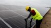 FILE - A technician works on solar power panels at the Atlantic Shrimpers farm in Badagry, Lagos, Nigeria, July 5, 2022. 