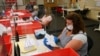 FILE — Election workers inspect ballots that have been received for the Sept. 14, recall election, for damage at the Sacramento County Registrar of Voters office in Sacramento, California, Aug. 30, 2021. 