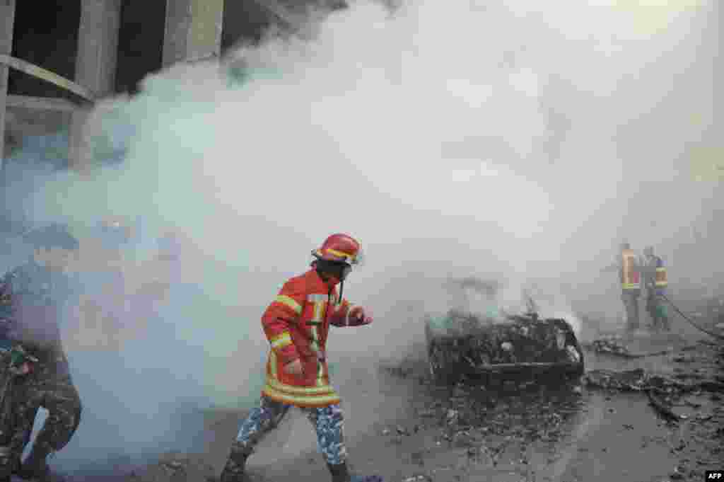 Lebanese security forces and firefighters inspect the scene of a a car bomb explosion that rocked central Beirut. The huge explosion killed Mohamed Chatah (Shatah), former finance minister and adviser to Lebanese ex-premier Saad Hariri and left at least five people dead and dozens injured.