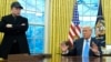President Donald Trump speaks with reporters as Elon Musk listens in the Oval Office at the White House, Feb. 11, 2025, in Washington. 