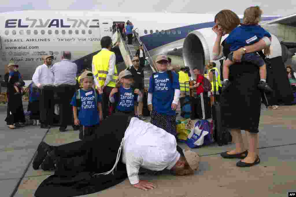 Seorang imigran Yahudi yang bersama keluarganya baru tiba dari Amerika 'sujud syukur' dengan mencium landasan saat kedatangan mereka di Bandara Internasional Ben Gurion dekat Tel Aviv, Israel.