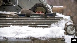 2022年1月28日，在乌克兰东部卢甘斯克地区的前线阵地附近，一名乌克兰军人从装甲运兵车上向外凝视。（美联社）