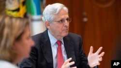 Deputy Attorney General Lisa Monaco, left, looks on as Attorney General Merrick Garland delivers a statement following a briefing on a fugitive apprehension initiative at the Department of Justice in Washington, July 6, 2022.