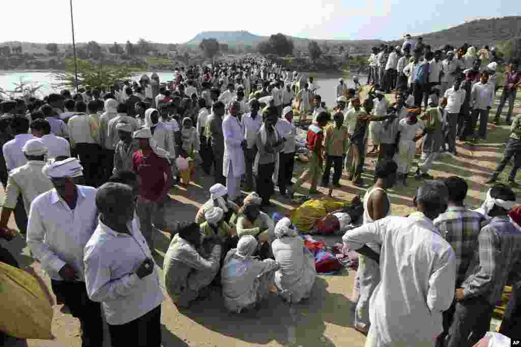 Villagers gather after a deadly stampede on a bridge across the Sindh River in Datia district in Madhya Pradesh state, India, Oct. 13, 2013.