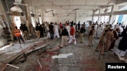 Para pejabat, regu penyelamat dan wartawan tampak di lokasi pemboman bunuh diri si sebuah masjid Syiah di Peshawar, Pakistan (21/6).