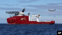 FILE - A Royal Australian Air Force AP-3C Orion flies past Australian Defense vessel Ocean Shield on a mission to drop sonar buoys to assist in the acoustic search of the missing Malaysia Airline jet.