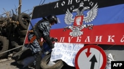 Pria bersenjata pro-Rusia di sebuah pos pemeriksaan di luar kota Slavyansk, Ukraina timur (26/4). (AFP/Max Vetrov)