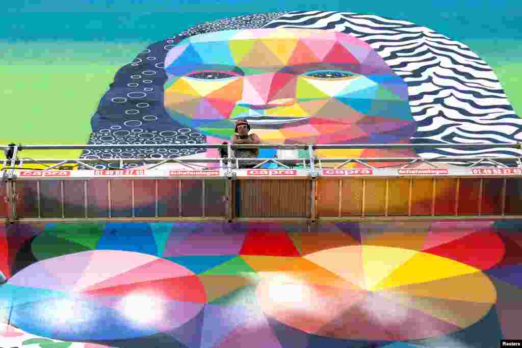 Pelukis Spanyol, Okuda berpose dengan lukisan mural setinggi 50-meter karyanya yang menggambarkan sosok "Mona Lisa" di Paris, Perancis.