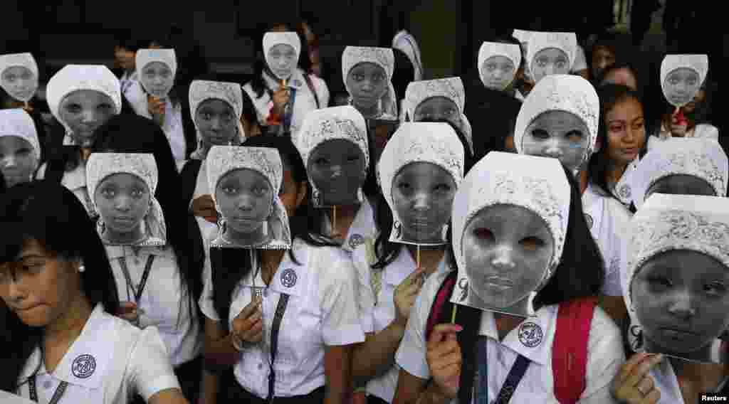 Para siswi Sekolah Putri Katolik, St. Scholastica College, di Manila, Filipina, menutup wajahnya dengan topeng yang menggambarkan para siswi yang diculik oleh militan Boko Haram di Afrika. Lebih dari 1.000 siswi ambil bagian dalam protes yang ditujukan untuk menyuarakan kemarahan atas penculikan lebih dari 200&nbsp; siswi sekolah di Timur Laut Nigeria pada bulan April oleh kelompok militan itu. &nbsp; 