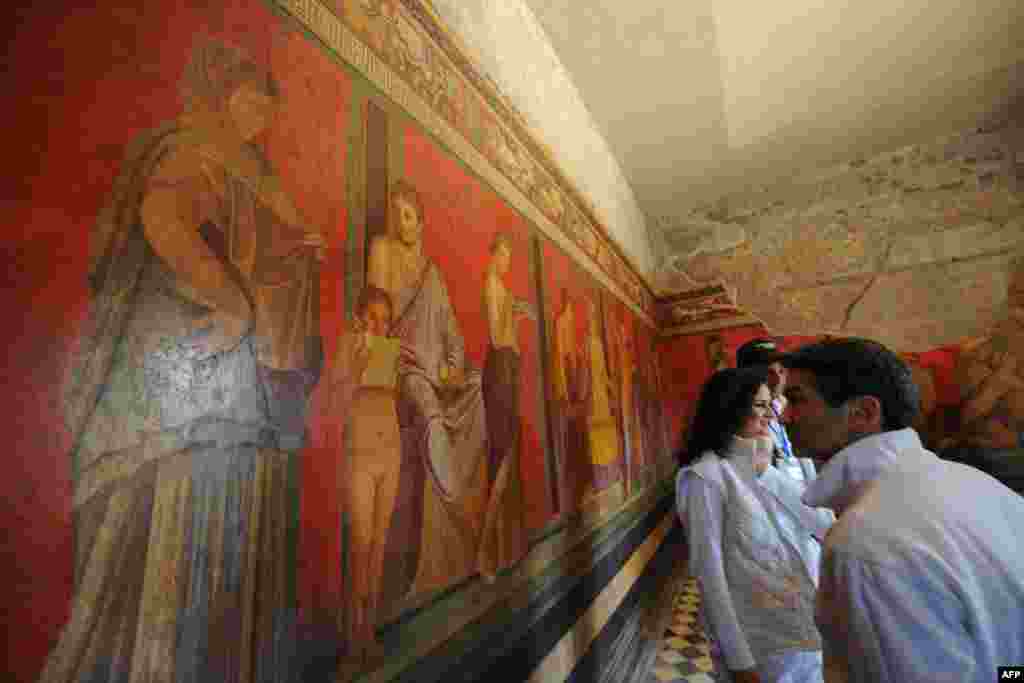 Seorang pengunjung berjalan di Vila Misteri di Roma yang baru saja diperbaiki dan dibuka kembali bagi publik. Vila ini terletak di situs arkeologi Pompeii, di Italia.