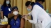 A health worker injects China's Sinovac vaccine on a colleague during the first batch of vaccination at the Lung Center of the Philippines in Quezon city, Philippines on Monday, March 1, 2021. 