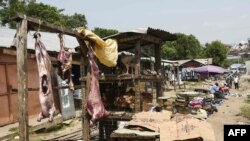 People sit and go about their daily life at the food market in Mpondwe by the border check point, between Uganda and the Democratic Republic of Congo, on June 13, 2019