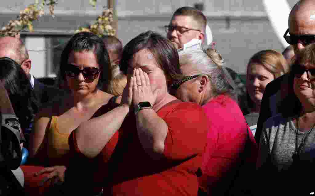 Laura Smith, center, holds her head in her hands during the 85 seconds of silence to honor the 85 people who died in last year&#39;s Camp Fire during ceremonies in Paradise, Calif., Nov. 8, 2019.
