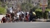 People seek shelter from gunfire at an army base in Yemen's southern port city of Aden, March 25, 2015. 
