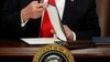 U.S. President Donald Trump prepares to sign an executive order at Homeland Security headquarters in Washington, Jan. 25, 2017.