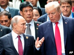 FILE - U.S. President Donald Trump, right, and Russia's President Vladimir Putin talk during the family photo session at the APEC Summit in Danang, Nov. 11, 2017.