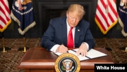 Le président Donald J. Trump signe une ordonnance sur les sanctions contre l'Iran, le 5 août 2018. 