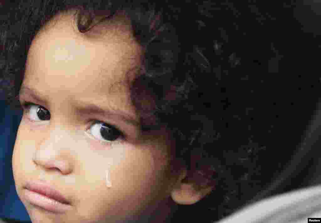 Jaden Fabian, 1, cries in her car seat as her family evacuates their home as Tropical Storm Isaac heads towards the Louisiana coast line, August 28, 2012.