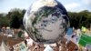 FILE - A large inflatable globe is bounced through the crowd as thousands of protestors, many of them school students, gather in Sydney, Friday, Sept. 20, 2019, calling for action to guard against climate change. 
