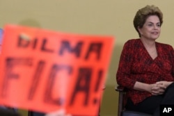 Brazil’s President Dilma Rousseff attends having in front a poster written in Portuguese "Dilma Stay, during ceremony of the Launch Program New Federal Universities, at the Planalto Presidential Palace, in Brasilia, May 9, 2016.