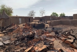 FILE - A general view shows the damage at the site of an attack on a village in Mali, June 11, 2019.