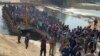 FILE - In this photo released by Royal Thai Army, more than 250 people from 20 nations who were reportedly rescued from alleged scam centers in Myanmar, are seen as they cross into Thailand's Tak province on Feb. 12, 2025. 