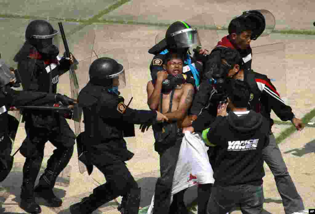 Polisi anti huru-hara Thailand menahan seorang demonstran anti-pemerintah di Bangkok. 