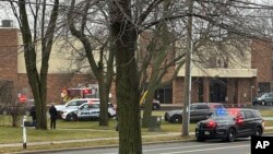 Emergency vehicles are parked outside the Abundant Life Christian School in Madison, Wis., where a shooting occurred, Dec. 16, 2024. A teacher, a student and the shooter were killed, police said.