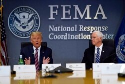 President Donald Trump speaks during a Hurricane Laura briefing at FEMA headquarters, Aug. 27, 2020, in Washington. Vice President Mike Pence listens at right.