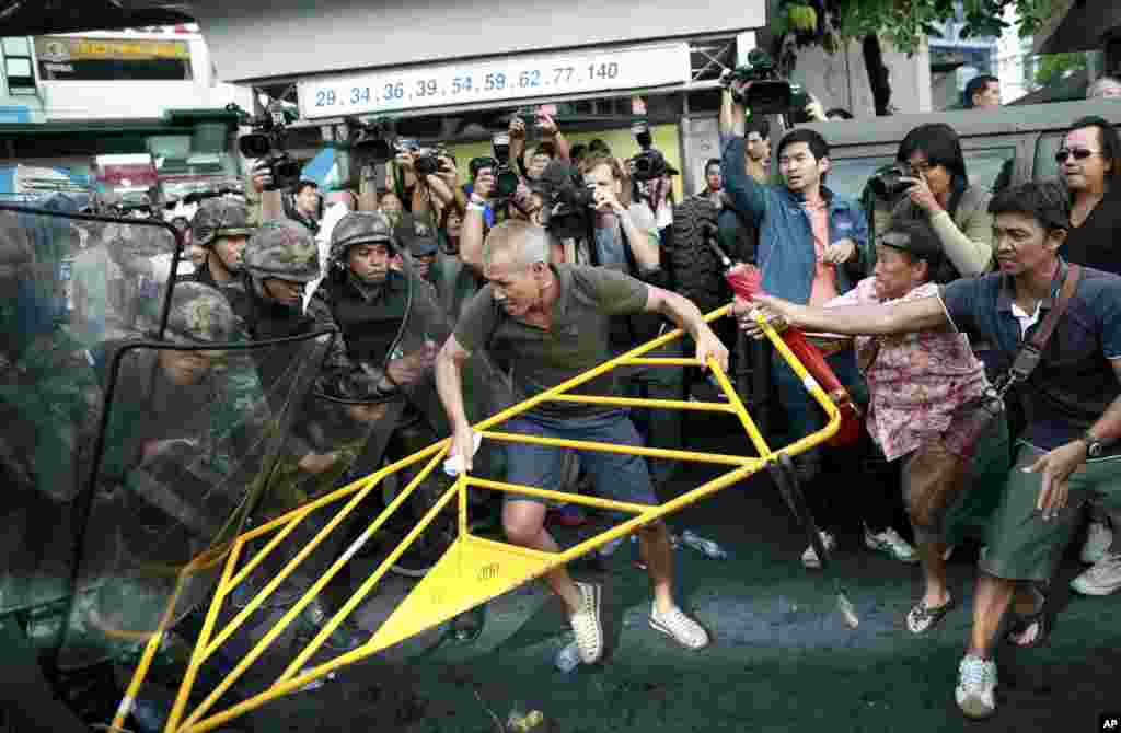 Para demonstran bentrok dengan tentara Thailand dalam protes anti-kudeta di Monumen Kemenangan di Bangkok.