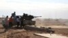 FILE - Fighters are seen firing a vehicle-mounted weapon on the outskirts of Sidra, Libya, Dec. 14, 2014.