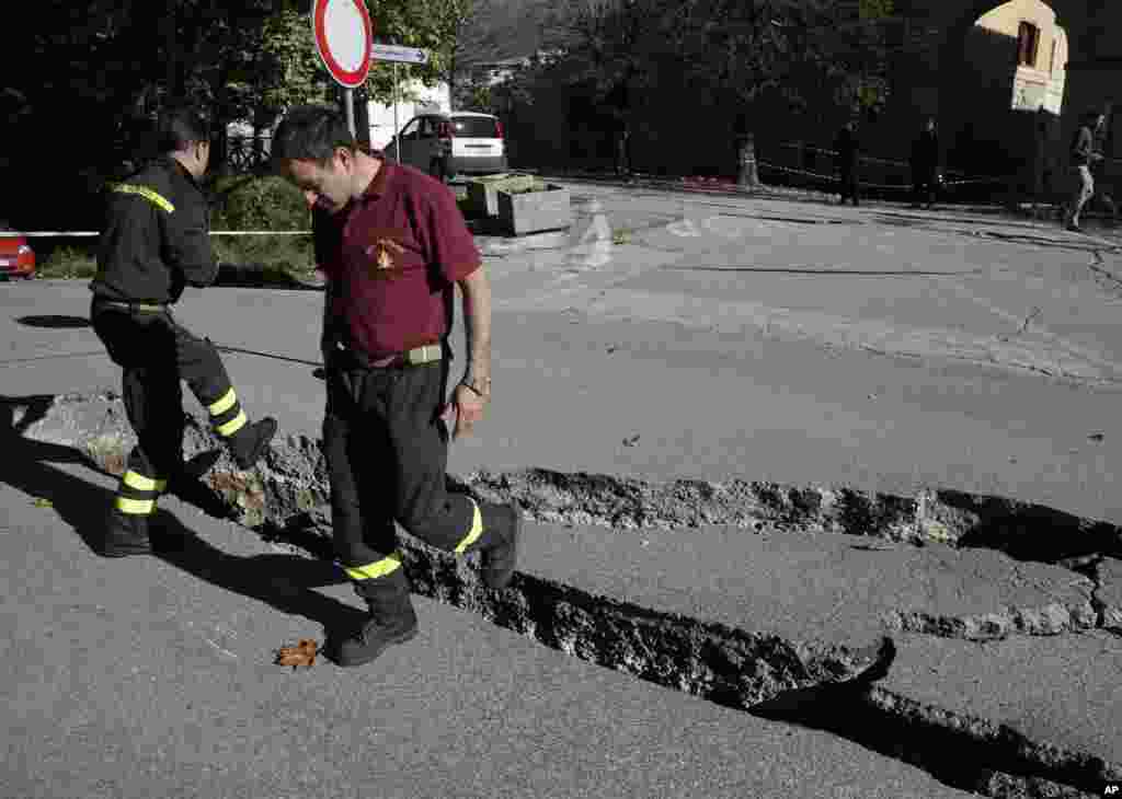 Firefighters inspect cracks in a road in Norcia, central Italy, after an earthquake with a preliminary magnitude of 6.6 struck central Italy, Oct. 30, 2016. Central Italy was hit by another powerful earthquake, toppling buildings that had recently withstood other major quakes and sending panicked residents back into the streets, but causing no immediate loss of life. 