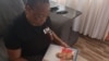 Torkwase Kuraun, Sister of missing journalist Tordue Salem, looks at pictures of him in the family photo album at her home in Abuja, Nov. 4, 2021. (Timothy. Obiezu/VOA)