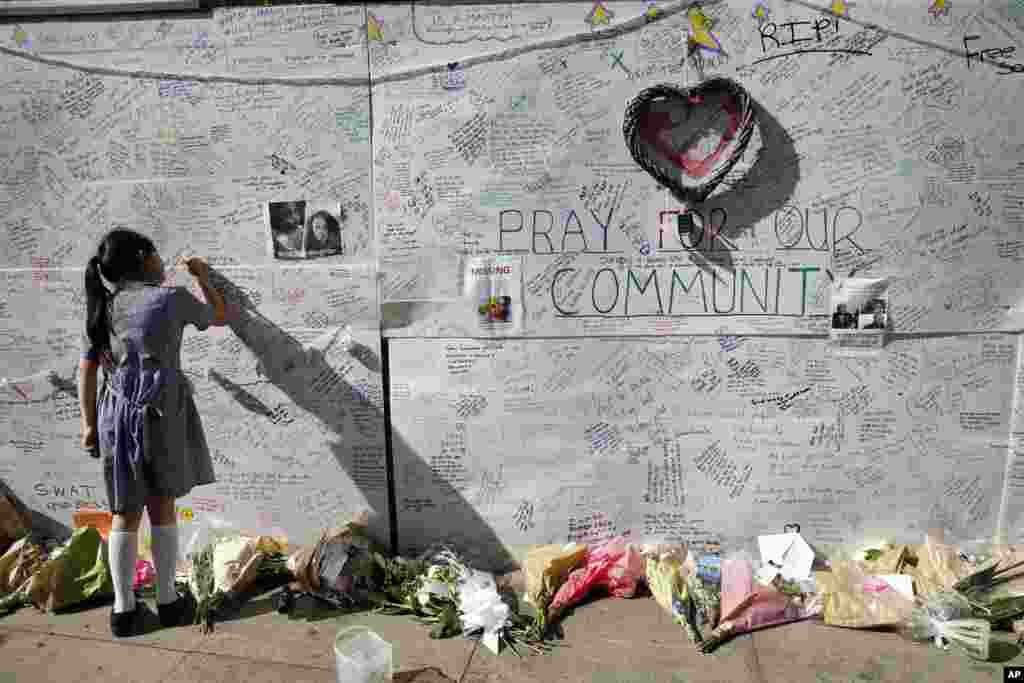 Seroang siswi sekolah menulis pesan untuk memberi dukungan solidaritas kepada korban kebakaran gedung apartemen "Grenfell Tower" di London.