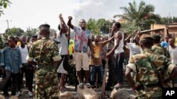 Des manifestants opposés à la candidature du président Pierre Nkurunziza font face aux militaires, le 27 mai 2015.