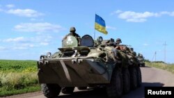 Sebuah kendaraan militer berbendera Ukraina tampak di dekat pos pengecekan di Slaviansk di timur Ukraina, 3/7/2014. 