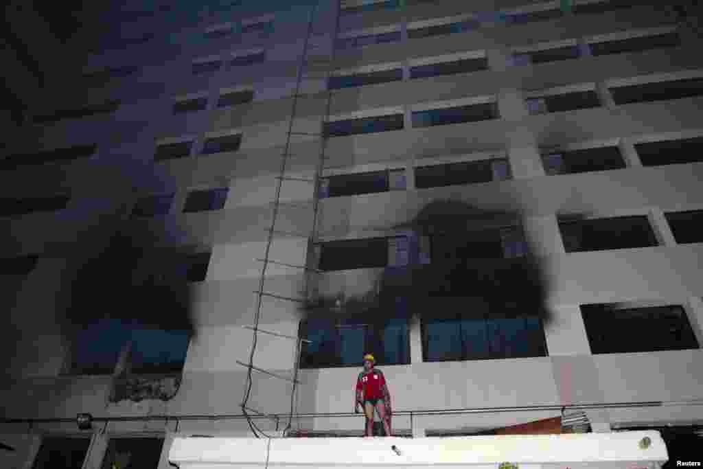 A fire fighter works outside a factory where a deadly fire occurred in Dhaka, Bangladesh, May 9, 2013. 