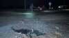 Police officers work next to a crater that appeared after a Russian drone strike, amid Russia's attack on Ukraine, in Kharkiv, Ukraine, March 26, 2024.