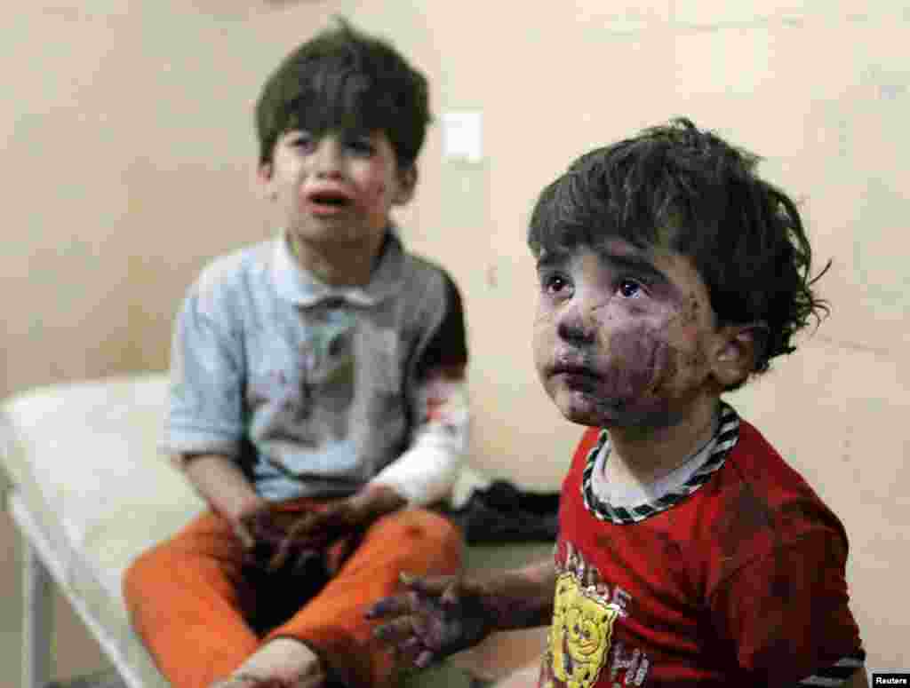 Anak-anak yang cedera menangis setelah, menurut para aktivis, dua bom barrel dilemparkan oleh tentara yang setia kepada Presiden Suriah Bashar al-Assad di wilayah Hullok Aleppo,1 April 2014. 