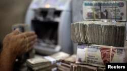 Un employé compte les billets dans un bureau de change au Caire, Egypte, le 5 juin 2014. 