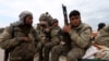 Kurdish People's Protection Units (YPG) fighters carry their weapons while riding on the back of a pick-up truck in Qamishli, Syria, March 11, 2016. 