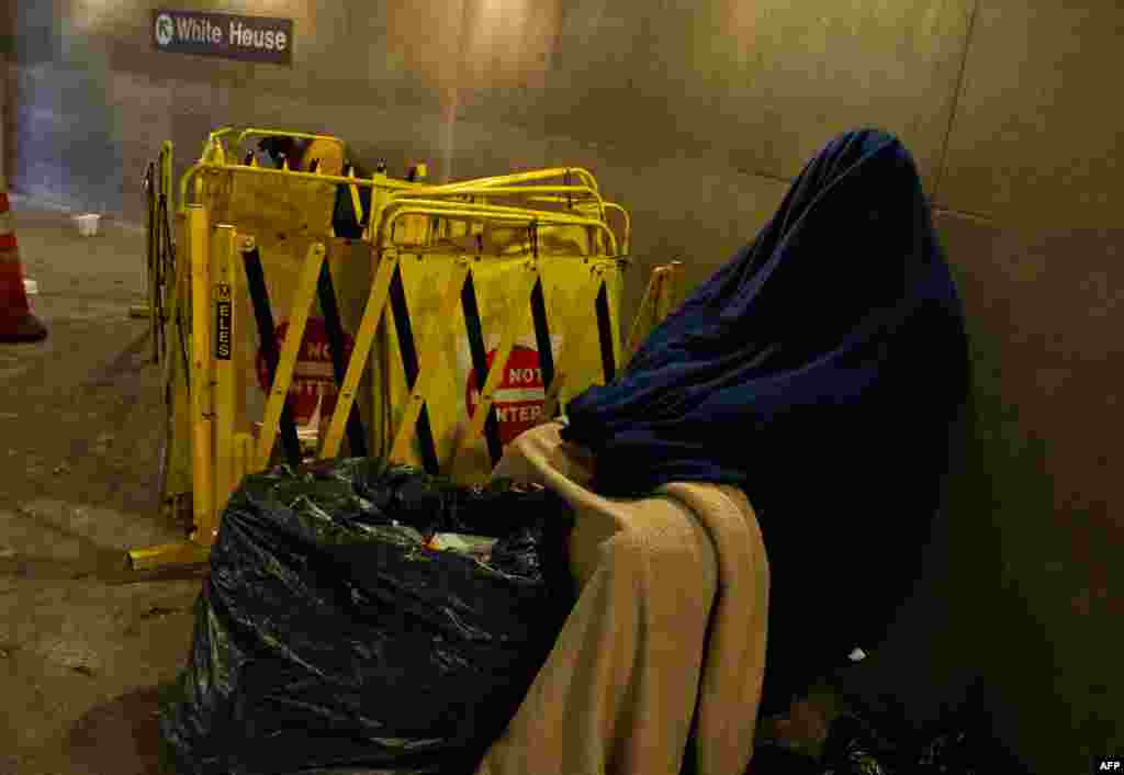 A homeless man bundled against the cold, tries to get some sleep at a Metro station as temperatures dipped into the single digits Fahrenheit and minus degrees with the wind chill in Washington, DC.