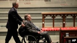 美国前总统小布什推着坐在轮椅上的父亲、前总统老布什抵达休斯顿的圣马丁圣公会教堂，参加前第一夫人芭芭拉·布什的葬礼仪式。（2018年4月21日） 