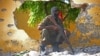 FILE - A Somali soldier stands guard next to the site where al-Shabab militants carried out a suicide attack against a military intelligence base in Mogadishu, June 2015.