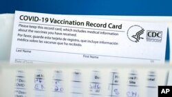 FILE - A vaccination record card is shown during a COVID-19 vaccination drive for Spring Branch Independent School District education workers, March 16, 2021, in Houston, Texas.