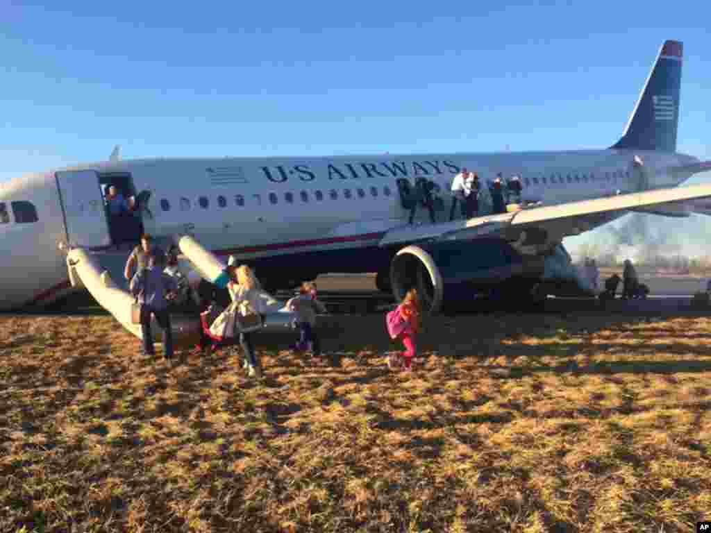 Para penumpang mengevakuasi pesawat&nbsp; US Airways 1702 setelah pilot pesawat itu terpaksa membatalkan lepas landas segera setelah pukul 18:00, ketika&nbsp; ban depan pesawat itu pecah di Philadelphia, 13 Maret 2014. Pesawat Jet Airbus A320 itu, terbang dengan tujuan Fort Lauderdale, Florida, membawa 149 penumpang dan lima awak pesawat, demikian dikatakan&nbsp; juru bicara bandara, Victoria Lupica. 