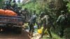 Des soldats des Forces de défense congolaises enlèvent les corps des victimes d'une attaque près de la ville d'Oicha, à 30 km de Beni, en République démocratique du Congo, le 23 juillet 2021. 